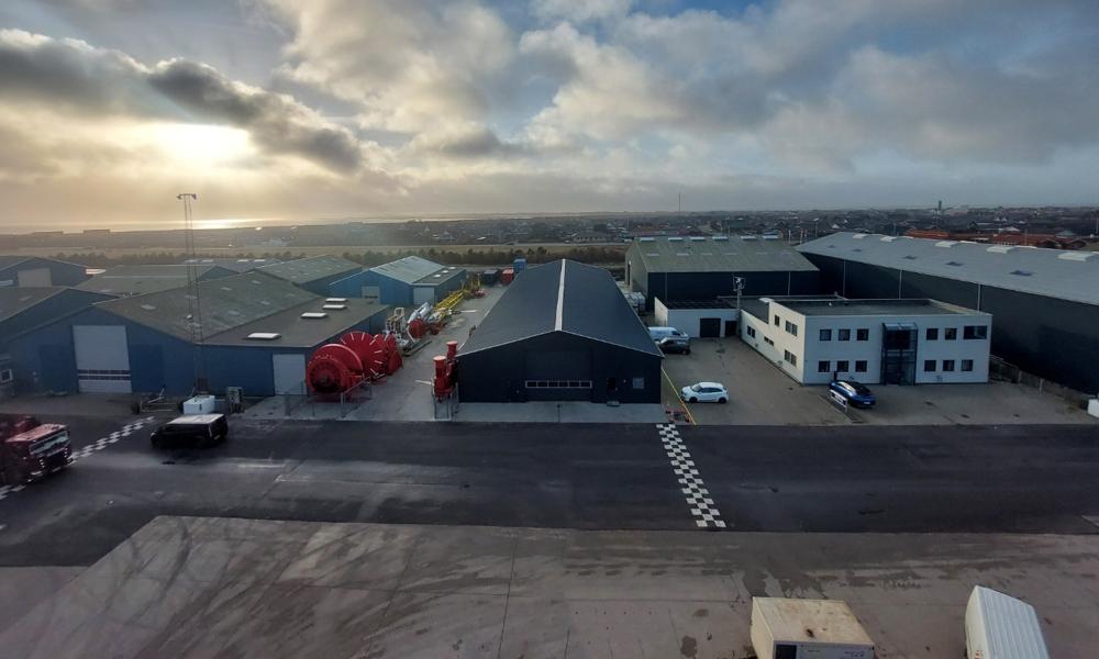 JD-Contractors nye operationsbase i Thyborøn Havn breder sig over et areal på 1.800 kvm. og omfatter kajnære lager-, værksteds- og kontorbygninger. JD-Contractors nye operationsbase i Thyborøn Havn breder sig over et areal på 1.800 kvm. og omfatter kajnære lager-, værksteds- og kontorbygninger.