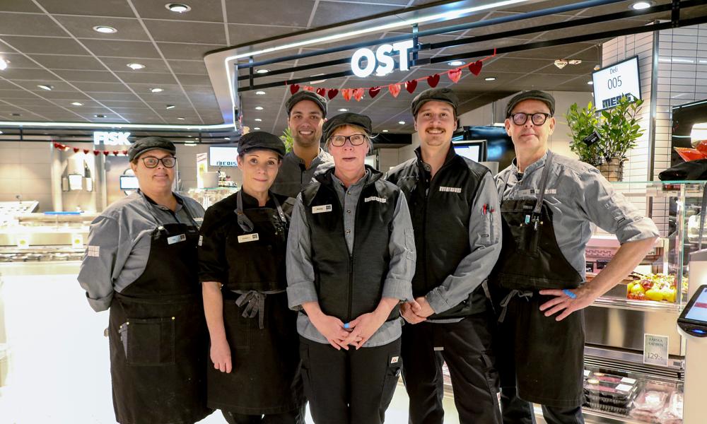 Ica Supermarket Medis medarbetare, Kia, Anneli, Simon, Marie, Morgan och Per i delin visar stolta upp sina nya kläder med skjorta, väst och keps. Delipersonalen har en ståkrage på skjortan. Ica Supermarket Medis medarbetare, Kia, Anneli, Simon, Marie, Morgan och Per i delin visar stolta upp sina nya kläder med skjorta, väst och keps. Delipersonalen har en ståkrage på skjortan.
