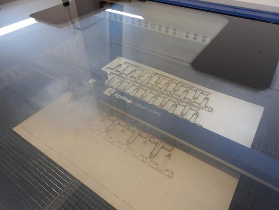 Her laves der bordkort i træ med laserprinteren. Man kan se røgen fra det brændte træ i printeren.