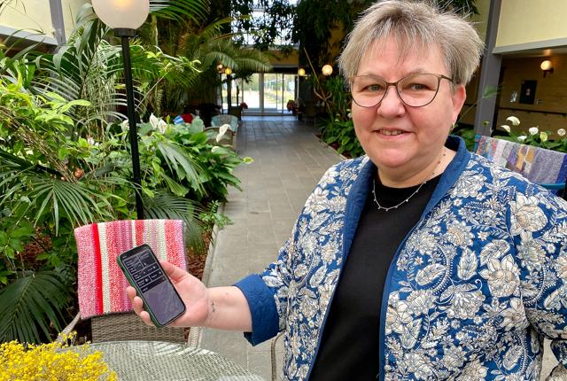 Plejehjemsleder Anne Marie Rosenkilde med telefonen, der er knyttet til det nye system, og som giver alarm, hvis der sker en utilsigtet hændelse hos en dement beboer.