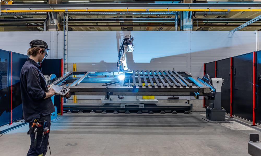 En svejserobotcelle håndterer og svejser store genstande såsom maskinrammer hos Amada Automation Europe. En svejserobotcelle håndterer og svejser store genstande såsom maskinrammer hos Amada Automation Europe.