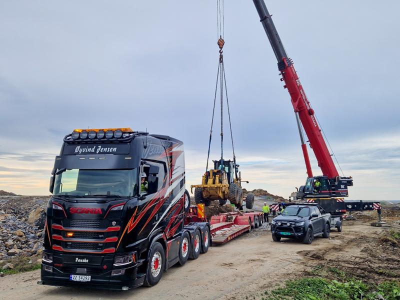 Her er mobilkranen fra Nordlandskrana AS i full gang med å løfte veihøvelen over på hengeren til Øyvind Jensen termotransport. Det gikk helt problemfritt. Her er mobilkranen fra Nordlandskrana AS i full gang med å løfte veihøvelen over på hengeren til Øyvind Jensen termotransport. Det gikk helt problemfritt.