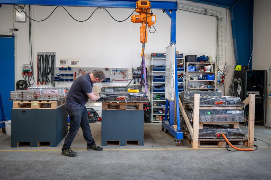 En ansat arbejder med at teste de brugte batterier for deres kvalitet. En ansat arbejder med at teste de brugte batterier for deres kvalitet.