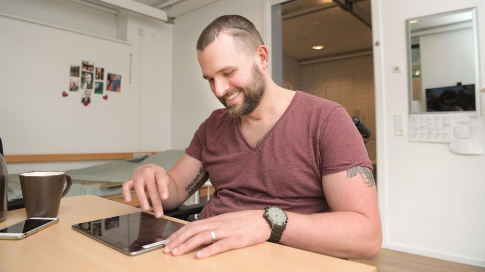 Jonas Thomsen Lorenzen er virkelig, virkelig glad for at være på Neurocenter Østerskoven i Hobro. Han får hjælp til at træne sig selv op efter en voldsom scooterulykke. Foto: Claus Søndberg