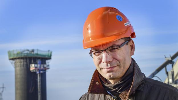 Teknisk direktør i Aalborg Forsyning, Jesper Høstgaard-Jensen, peger på at strømmen fra vindmøllerne skal bruges til at producere fjernvarme på Nordjyllandsværket. <i>Arkivfoto</i>