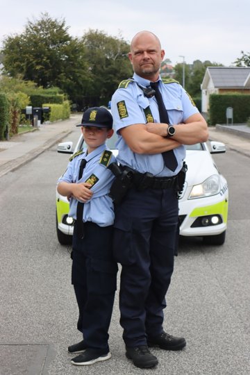 Otte-årige Victor Bilde Bach hjælper færdselsbetjent Kent Glinvad med at få bilisterne til at sænke farten. Foto: Aalborg Kommune