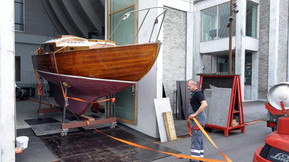 Det er Arne Nielsen og hans kollega, Ole Knudsen, fra Kruse Maskintransport, der står for det praktiske med at få den tre tons tunge båd bugseret ud på havnefronten. Senere på eftermiddagen bliver den hejst ind i atriumgården.Foto: Michael Bygballe <i>Michael Bygballe</i>