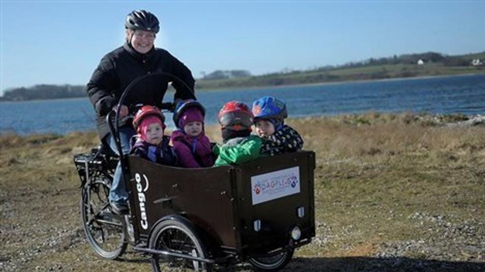 Julie, Emi, Annika og Chris har sat sig til rette i Østerild-dagplejernes ladcykel med elmotor. Det er Pia Jensen fra Hovsør, der kører en tur med de fire børn. Foto: Diana Holm