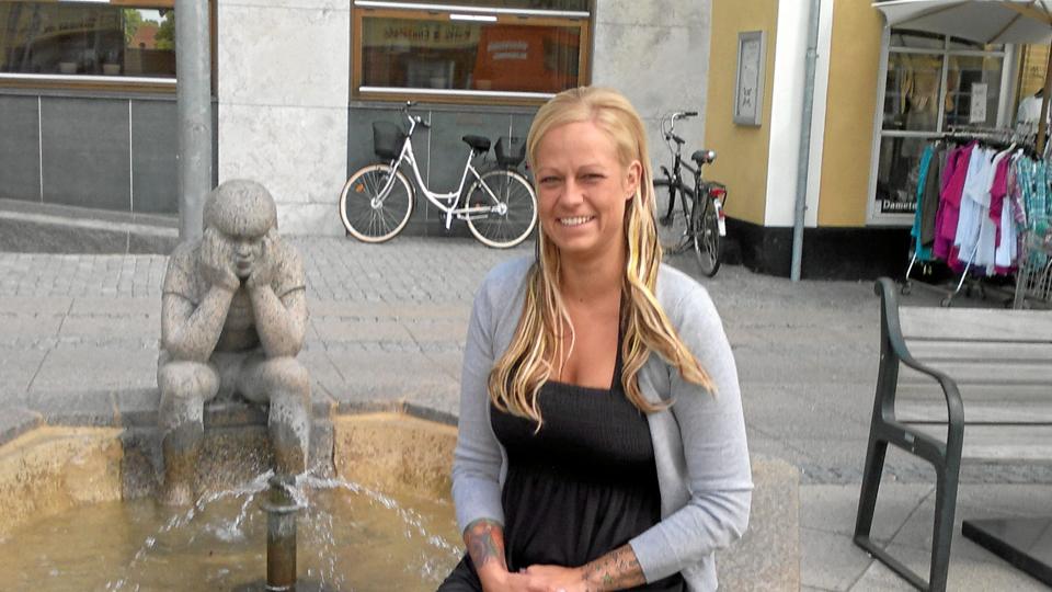 Frisør Camilla F. ved springvandet på Store Torv i Sæby - måske har stenhugger Sven Bovins ”Dreng i tanker” lyst til en klipning - eller en ekstension. Privatfoto.