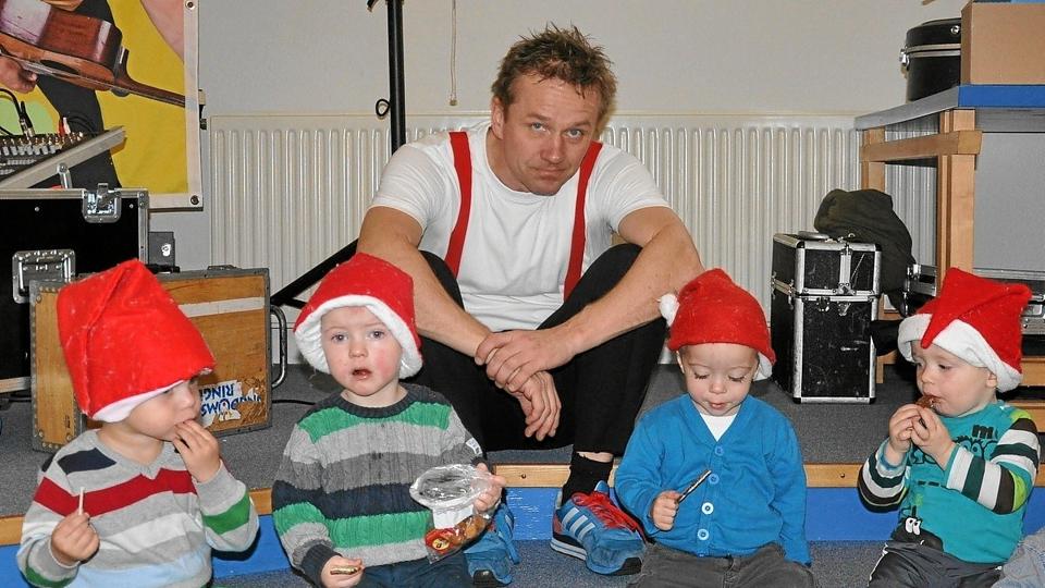Michael Back måtte pænt vente med at komme i gang med sit show, indtil de små nisser havde undersøgt indholdet i poserne fra julemanden nøjere. Det er Michael uden nissehue.Foto: Ole Torp <i>Ole Torp</i>