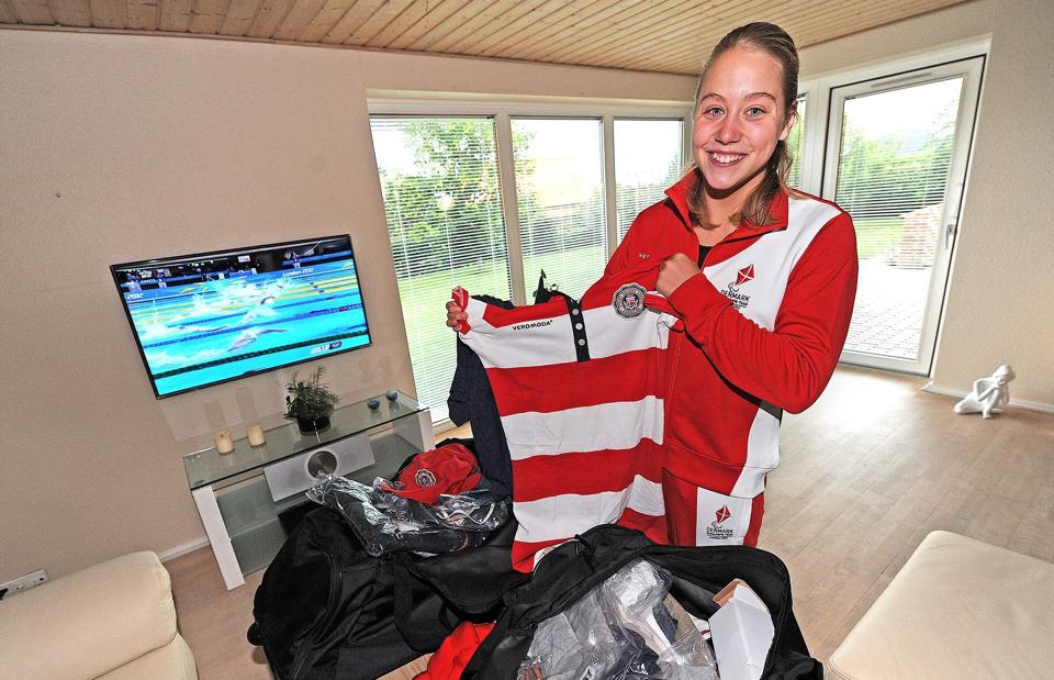 Mens fjernsynet kører med transmissioner fra de raskes svømmekonkurrencer ved OL, studerer Amalie Østergaard Vinther indholdet i de to kufferter med tøj og sko, som hun har modtaget op til OL for handicappede, der åbner i London 29. august.