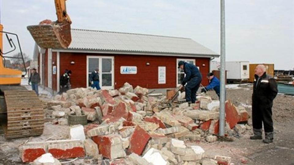 Det røde havnehus er nu murbrokker. Men fjernelse af huset var nødvendigt for at give plads til den ny terrasse med maritimscene, fortæller Niels Eske Nyhus, som til højre på billedet overvåger nedrivningen. Foto: Flemming Dahl Jensen