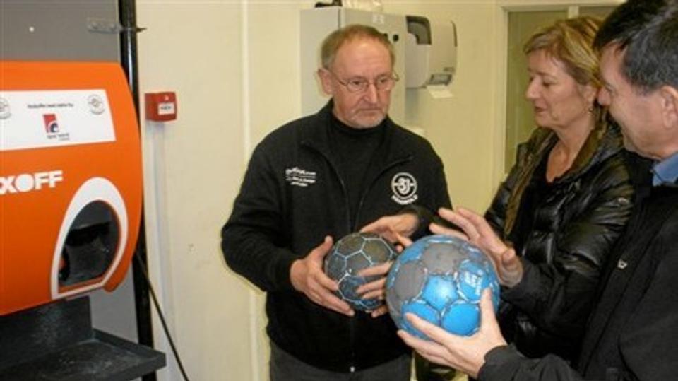 Per Jensen viser forskellen på en rengjort, og en ikke rengjort bold, til direktør Annette Drivsholm og bankrådsformand Jesper Hardahl.