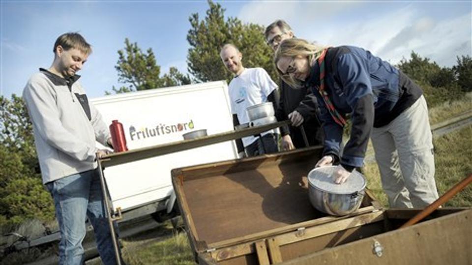 Hverken grej, transportkasser eller trailer er endnu indkøbt til den grejbank, som Klitmøller vil etablere under navnet Friluftsnørd. Men nogle af initiativtagerne demonstrerer her, hvordan det kunne foregå, når en kasse med grej til et udekøkken bliver pakket. Fra venstre Marin Eigenbroth, formand for Aktivt Børneliv i Klitmøller, Thomas Baun, der er formand for Klitmøller Friskole, Flemming Holler, medlem af Landsbygruppen Thy, samt Grethe Mejlgaard, der er tropsfører hos Klitmøller-spejderne. Simon Rauh, lærer på Klitmøller Friskole, skal være projektkoordinator for Friluftsnørd, men kunne ikke være til stede ved præsentationen af projektet. Foto: Diana Holm