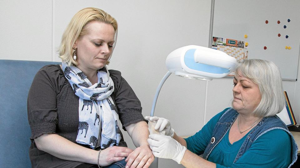 Sygeplejerske Lisette Korsholm (th) viser på Charlotte Bundgaard, at der også kan skiftes forbindinger på klinikken.Foto: Niels Helver <i>Niels Helver</i>
