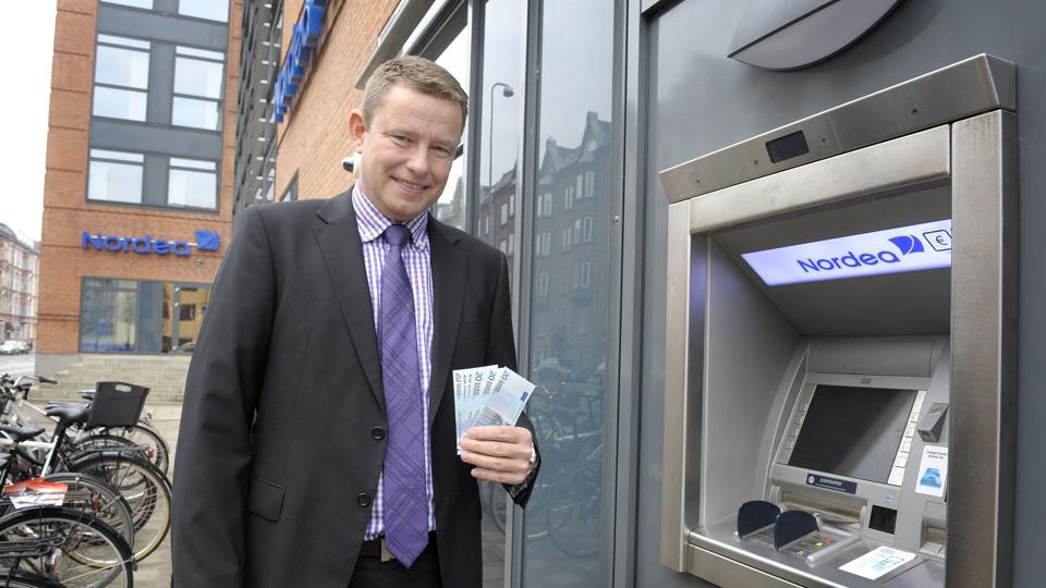Nordeas områdedirektør Torben Simonsen har puttet euro i pengeautomaten, man nu kan hæve euro, når banken har lukket. 	Foto: Michael Koch