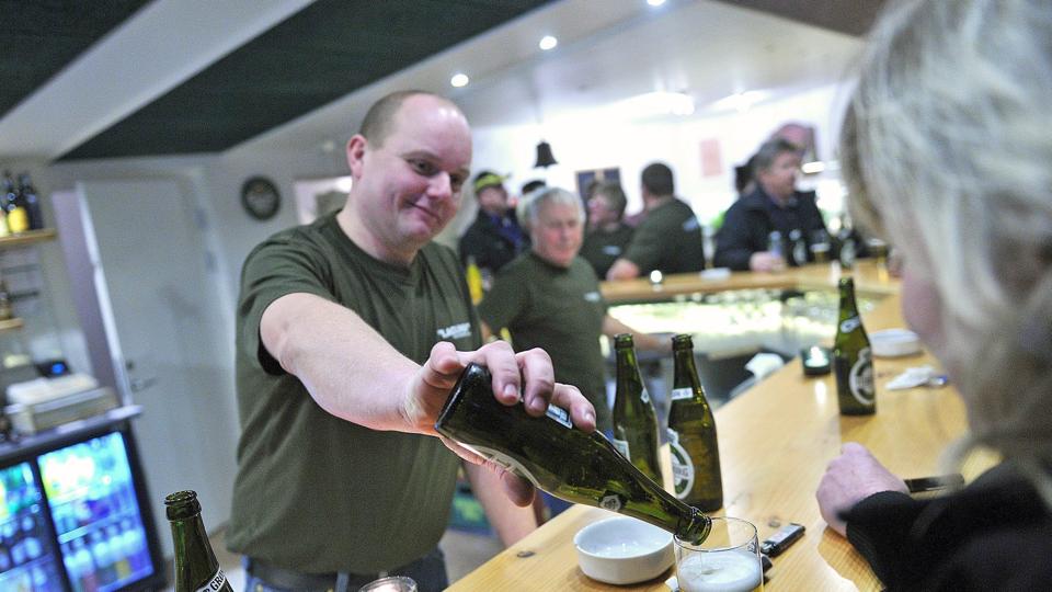Travlhed bag disken i den nybyggede bar. Ole Pedersen, en af de 15 bag bodegaprojektet, skænker op til åbningsreceptionen lørdag i Lagunen, som han selv har været med til at bygge. Foto: Ole Iversen