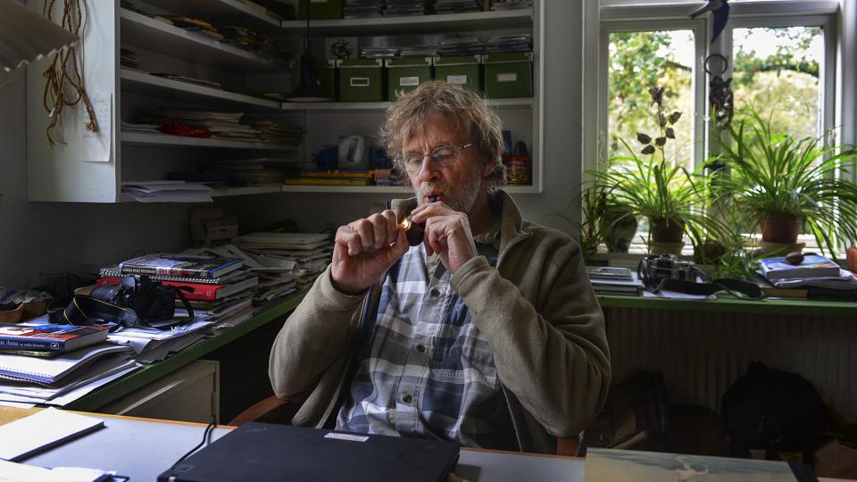 Søren Ryge i sit arbejdsværelse. Når der er ild i piben, flyder tankerne og dermed tastaturet lettere. Her bliver historierne derfor til - hvad enten det er til DR, Politiken eller en af hans efterhånden mange bøger. <i>Michael Bygballe</i>