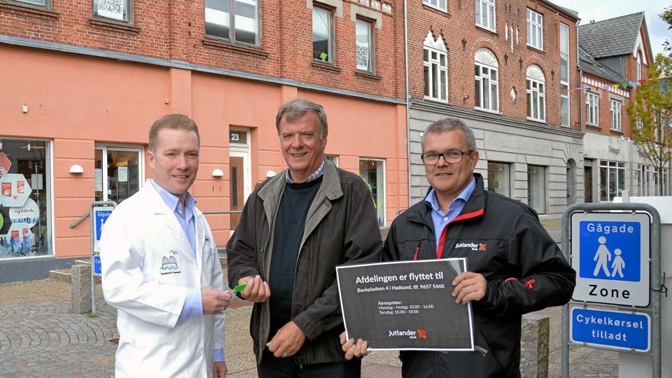 Hadsund Apotek, der ligger rundt om hjørnet i bunden af Storegade, kommer til at strække sig længere op i Hadsunds gågade. På billedet får apoteker Lars Walmar (t.v.) nøglerne overdraget til Storegade 25 (den grå bygning i forlængelse af det ferskenfarvede apotek) af ejendomschef i Jutlander Bank, Jørgen Krogh Pedersen. Til højre er det Mogens Chortsen, som er afdelingsdirektør i bankens Hadsund-afdeling, som tilbage i april flyttede til større lokaler på Bankpladsen i Hadsund. Privatfoto