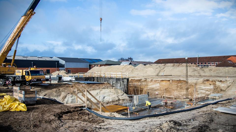 Afdelingen for de mindste elever på den nye Aabybro Skole er allerede for lille, inden fundamentet er støbt. Kommunen graver i øjelbikket dybt efter mulige løsninger. Man overvejer blandt andet at bevare dele af den gamle røde skole (bagerst th.)