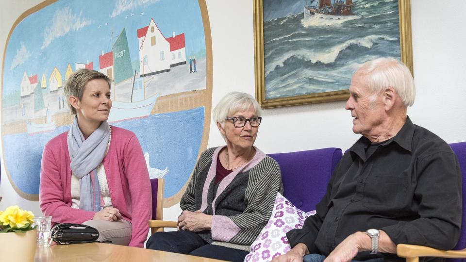 Trine Olesen, Alice Fjølner og John Pedersen sidder i de lyse lokaler på Strandgården. Det ovale billede i baggrunden er, ikke underligt, også malet af en frivillig. Foto: Peter Broen