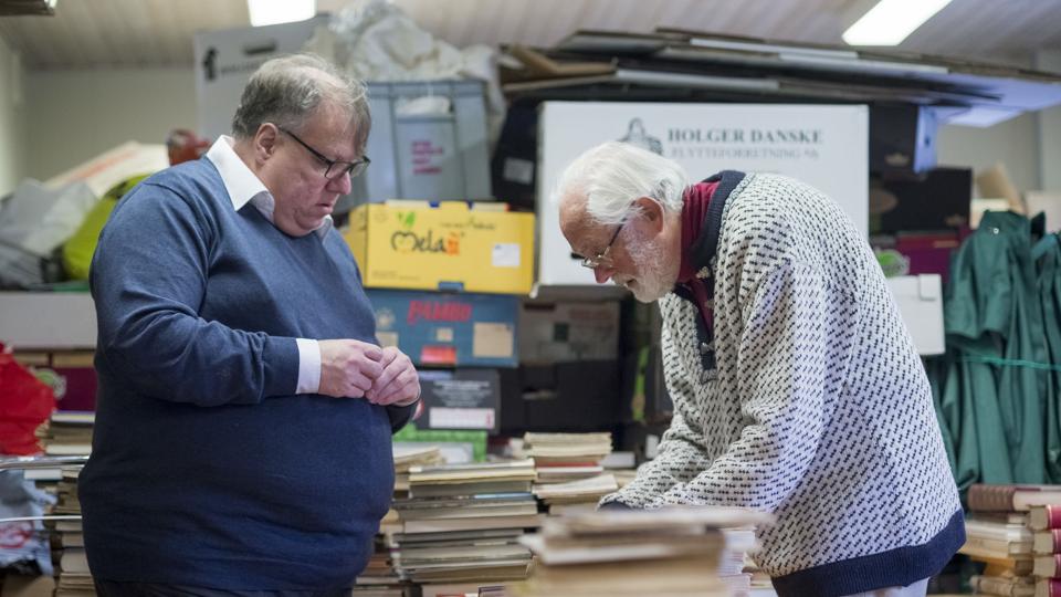 Bestyrelsesmedlem Henrik Bugge Mortensen (tv) og formand Hans Gullestrup i gang med at sortere de donerede bøger. <i>Nicolas Cho Meier - NORDJYSKE Medier</i>