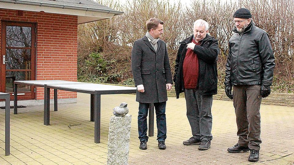 Folketingsmedlem Torsten Schack Pedersen, DUI-formand Poul Olsen og kommunalbestyrelsesmedlem Henning Sørensen ved den lille skulptur, som kræves fjernet af Naturstyrelsen. Foto: Leif Kristiansen