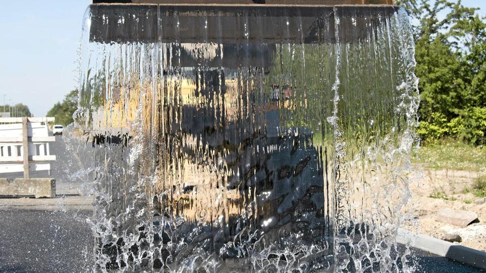 En grabfuld vand forsvinder ned i asfalten med det samme. Foto: Aalborg Kommune <i>Michael Bo Rasmussen / Baghuset</i>