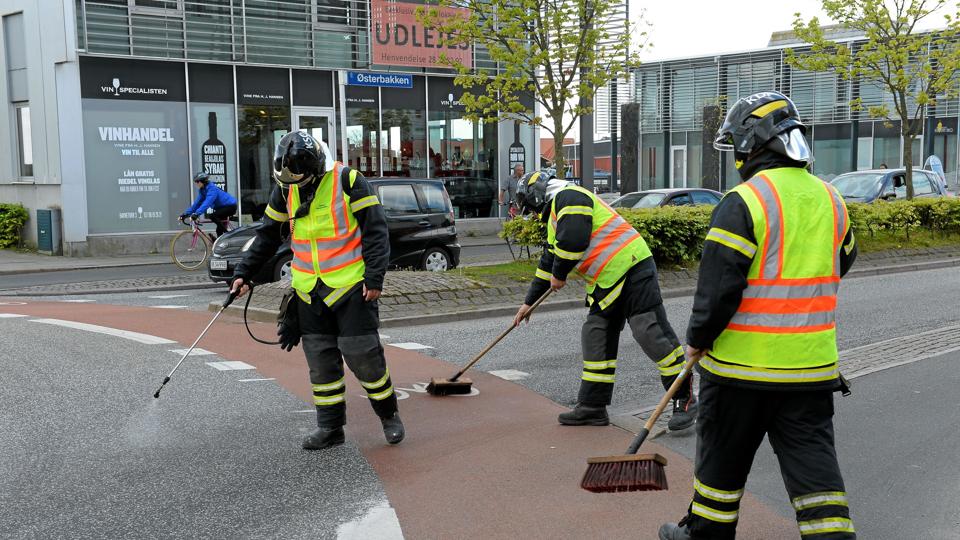 Beredskabet fra Thisted Kommune gik straks i gang med at fjerne olien fra vejbanen i og omkring rundkørslen ved Kino.Foto: Peter Mørk <i>Pressefotograf    Peter Moerk</i>