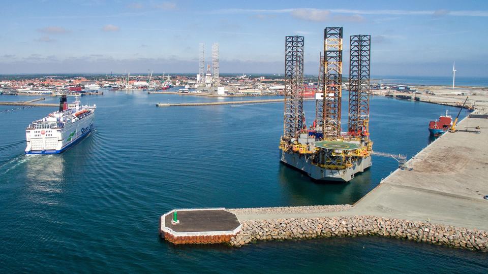 Færgen Stena Danica på vej ind i Frederikshavn Havn, der nu også har to store borerigge liggende. De to udtjente jackups, der venter på at blive hugget op, kan i klart vejr ses fra det meste af Vendsyssel. Foto: Peter Broen