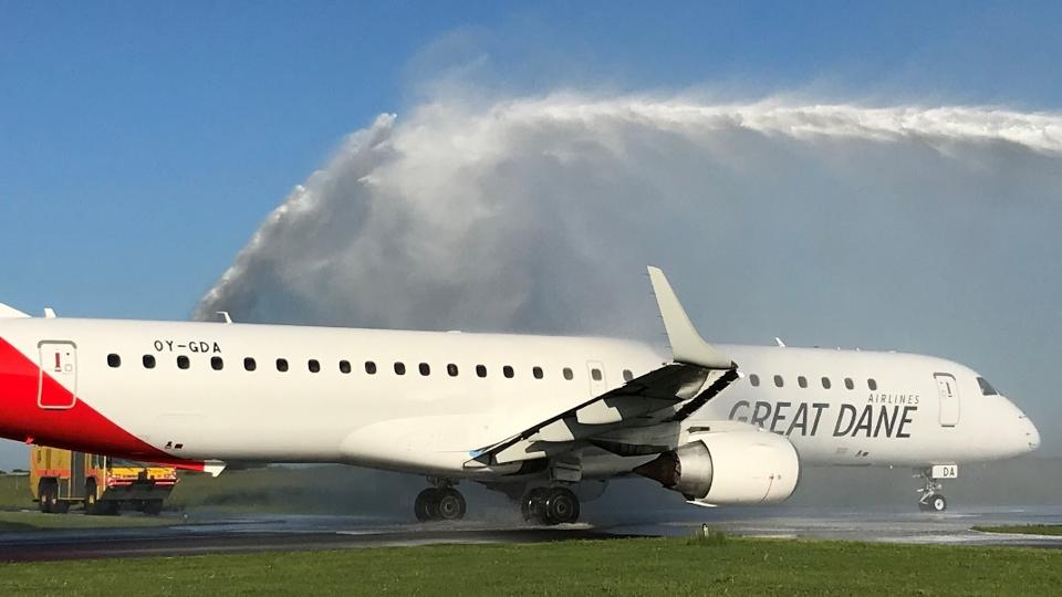 Jomfruflyvningen for Great Dane Airlines startede vådt fredag morgen - med ærefulde vandsprøjt fra lufthavnens brandslukningskøretøjer.
