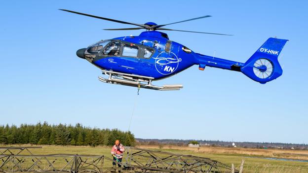 Mens pilot Martin Knudsen holdt helikopteren stille i luften, fik hjælperen på jorden, Niels Peter Kjeldahl, som faktisk er direktør for KN Helicopters løsnet bærestroppen og fartøjet kunne vende ud efter næste stump tårn. Foto: Bo Lehm <i>Bo Lehm</i>