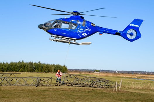 Mens pilot Martin Knudsen holdt helikopteren stille i luften, fik hjælperen på jorden, Niels Peter Kjeldahl, som faktisk er direktør for KN Helicopters løsnet bærestroppen og fartøjet kunne vende ud efter næste stump tårn. Foto: Bo Lehm <i>Bo Lehm</i>