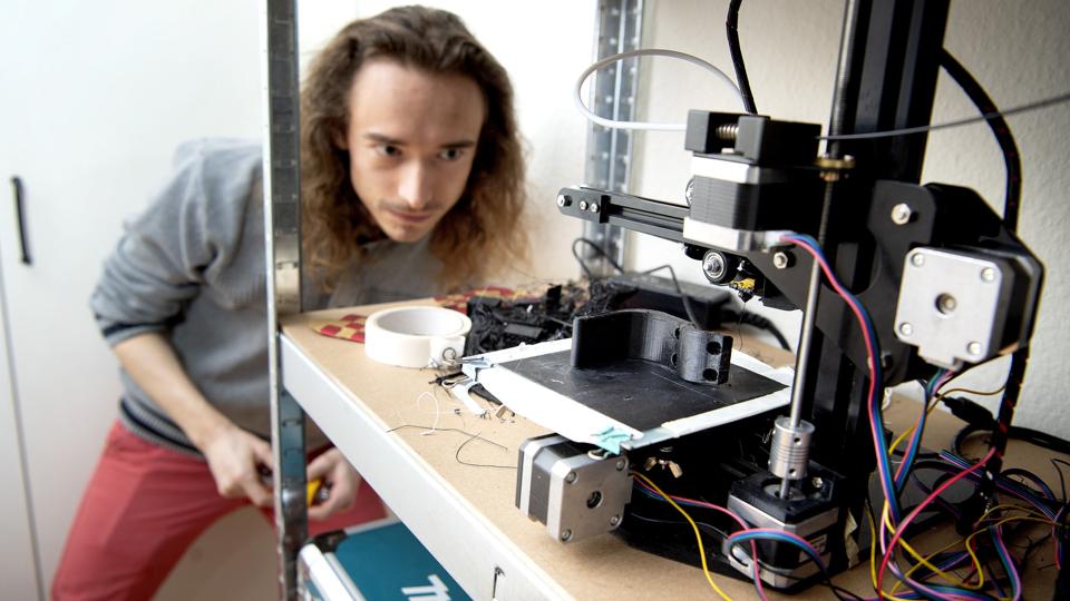 Daniel Hessellund Johansen i gang med at fremstille en håndfri døråbner på den 3D-printer, han har hjemme hos sig selv. Foto: Lars Pauli <i>Foto: Lars Pauli</i>