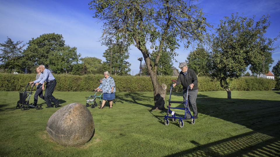 Bent Kraglund (i blå skjorte) glæder sig til at kunne træne lige uden for Rosengårdens hoveddør i stedet for at skulle tage en taxa til Brønderslev. Og den glæde deler han med to af Rosengårdens andre beboere, Grethe Juliane Henriksen og Aage Vorre. I midten af billedet ses plejecenterleder Anita Klit. Foto: Martin Damgaard