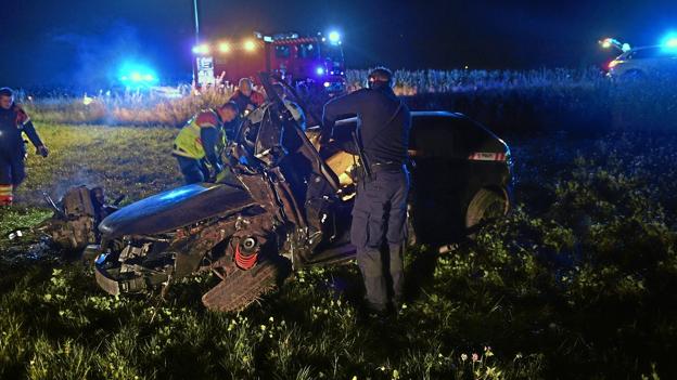 Politi og redningsmandskab ved bilen, som blev kraftigt beskadiget ved ulykken. Foto: Jan Pedersen