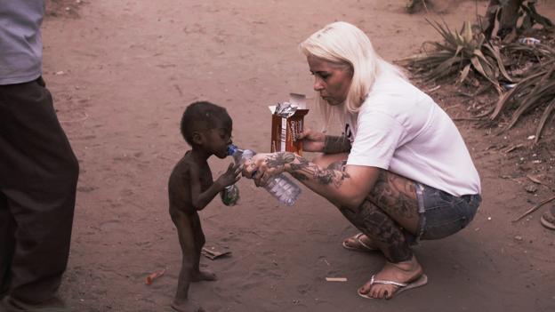 Anja Lovén giver lille Hope vand. Han er blevet udstødt af sin familie, fordi de tror, han er heksebarn. Foto: Privat
