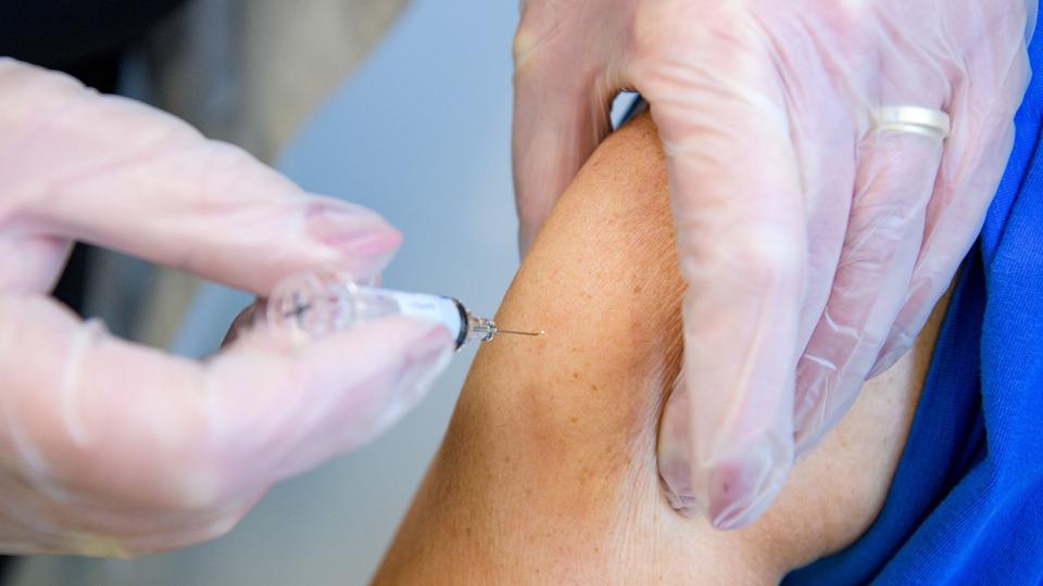 Man må ikke - som her - klemme huden sammen inden stikket - den skal spændes ud mellem tommelfinger og de øvrige fingre! Inden stemplet trykkes i bund skal den, der vaccinerer, sikre sig, at vaccinen ikke kommer i blodbanen, men i musklen, for at undgå blodpropper - det sker ved såkaldt aspiration - læs mere om det her i artiklen. Arkivfoto: Bo Lehm <i>Bo Lehm</i>