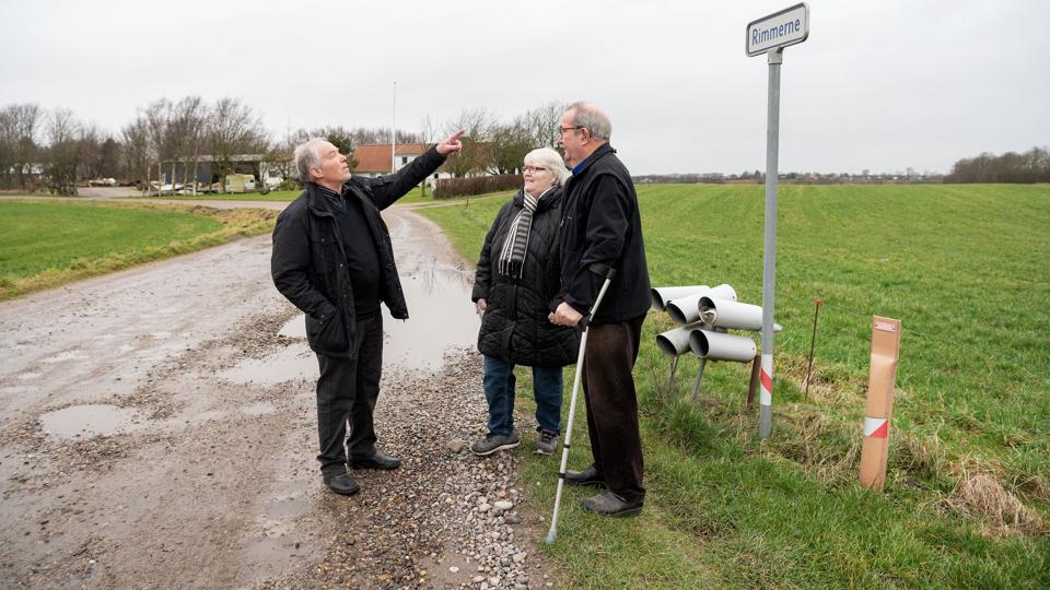 Den rigtige vej ind til ejendommene på Rimmerne er den, hvor vejskiltet står. Ole Svensson (til venstre) og hans naboer, Margit og Helge Krogh Hansen, har flere gange oplevet at ambulancer og vagtlæge er kørt forkert. Foto: Claus Søndberg