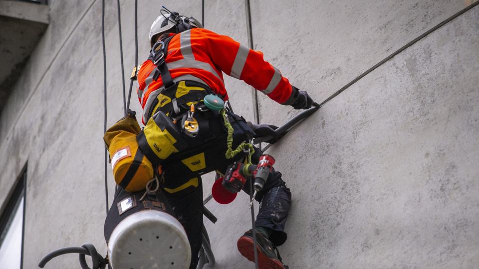 To medarbejdere fra Sky-Works arbejder i øjeblikket på at renovere fugerne på de to siloagtige beboelser på havnen i Nørresundby. Foto: Martel Andersen <i>Foto: Martél Andersen</i>