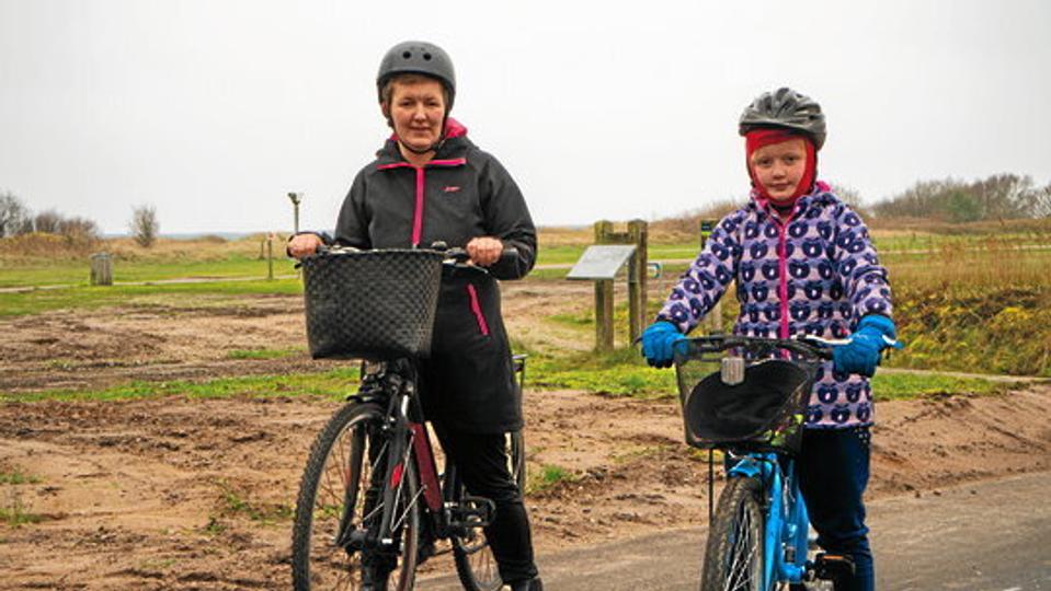 Heidi Bersang Hansen fra Helberskov har prøvekørt den nye cykelsti sammen med datteren, Emma. De er glade for, at cykelstien nu fører helt ud til stranden, så de trygt kan cykle dertil - også med deres spejdertrup. Foto: Mariagerfjord Kommune