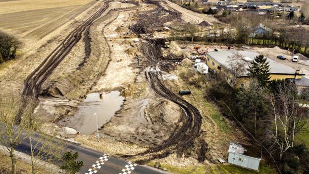 Vejen gennem det nye boligområde ender i den sydvestlige del ud i Strandvejen lige over for Haverslev Skole. Her har entreprenørmaskiner også travlt med at etablere de nødvendige hovedkloakledninger. Foto: Claus Søndberg