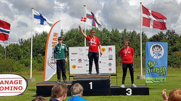 Antoni Leon Thessen (i midten) med sin guldmedalje om halsen og dannebrog i hænderne ved præmieoverrækkelsen. Privatfoto
