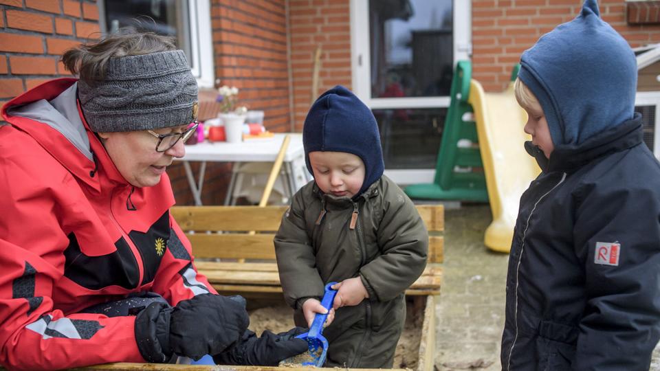 Dagplejer Jeanette Uggerly Boysen er uden for og lege i sandkassen med sine to dagplejebørn Lucas og Karlo. Hun synes, hun har verdens fedeste job, men hun kunne godt bruge lidt mere fritid. Foto: Martin Damgård