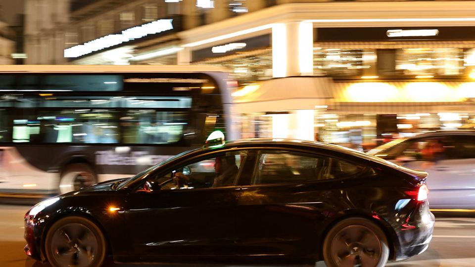 A man drives a Tesla taxi car in Paris <i>Sarah Meyssonnier/Reuters</i>