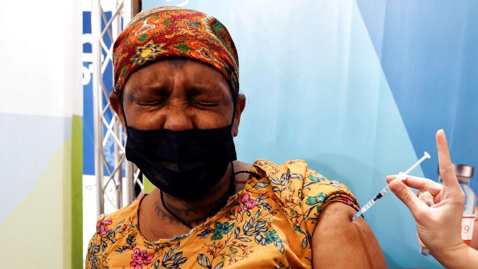 An Israeli woman receives her third dose of the COVID-19 vaccine, in Jerusalem <i>Ronen Zvulun/Reuters</i>
