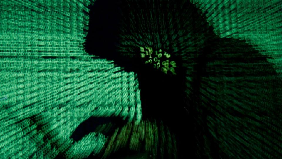 FILE PHOTO: Man holds laptop computer as cyber code is projected on him in this illustration picture <i>Kacper Pempel/Reuters</i>