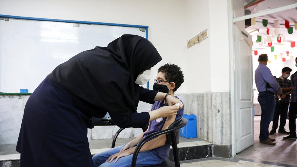 An Iranian teenager receives a dose of a vaccine against the coronavirus disease (COVID-19) at a school in Tehran <i>Wana News Agency/Reuters</i>
