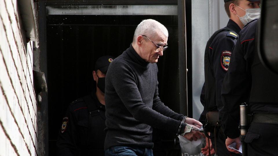 Russian historian Yuri Dmitriev is escorted by police officers after a court hearing in Petrozavodsk <i>Anton Vaganov/Reuters</i>