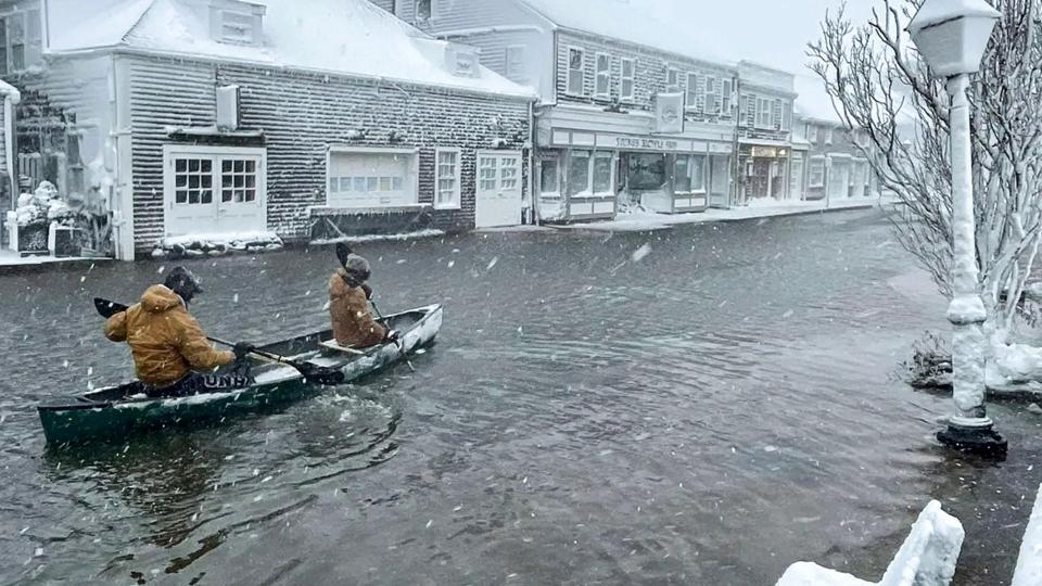 Nantucket High School students row a canoe along a road during heavy flooding, in Nantucket <i>Ian Williams/Reuters</i>